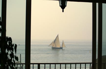 Sailing ship seen through open window.